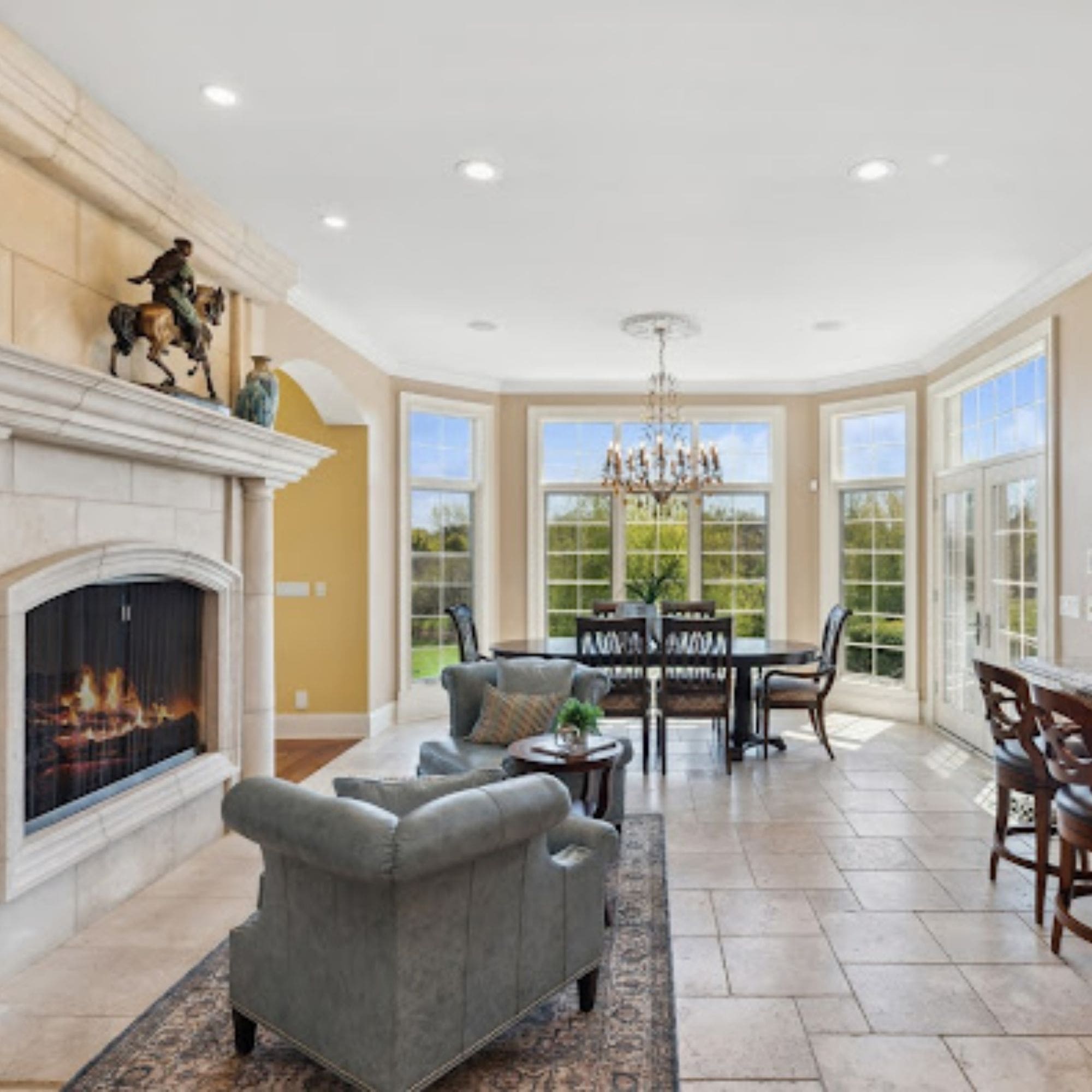 Spacious home staged living room featuring a cozy fireplace and a dining area, perfect for entertaining guests.