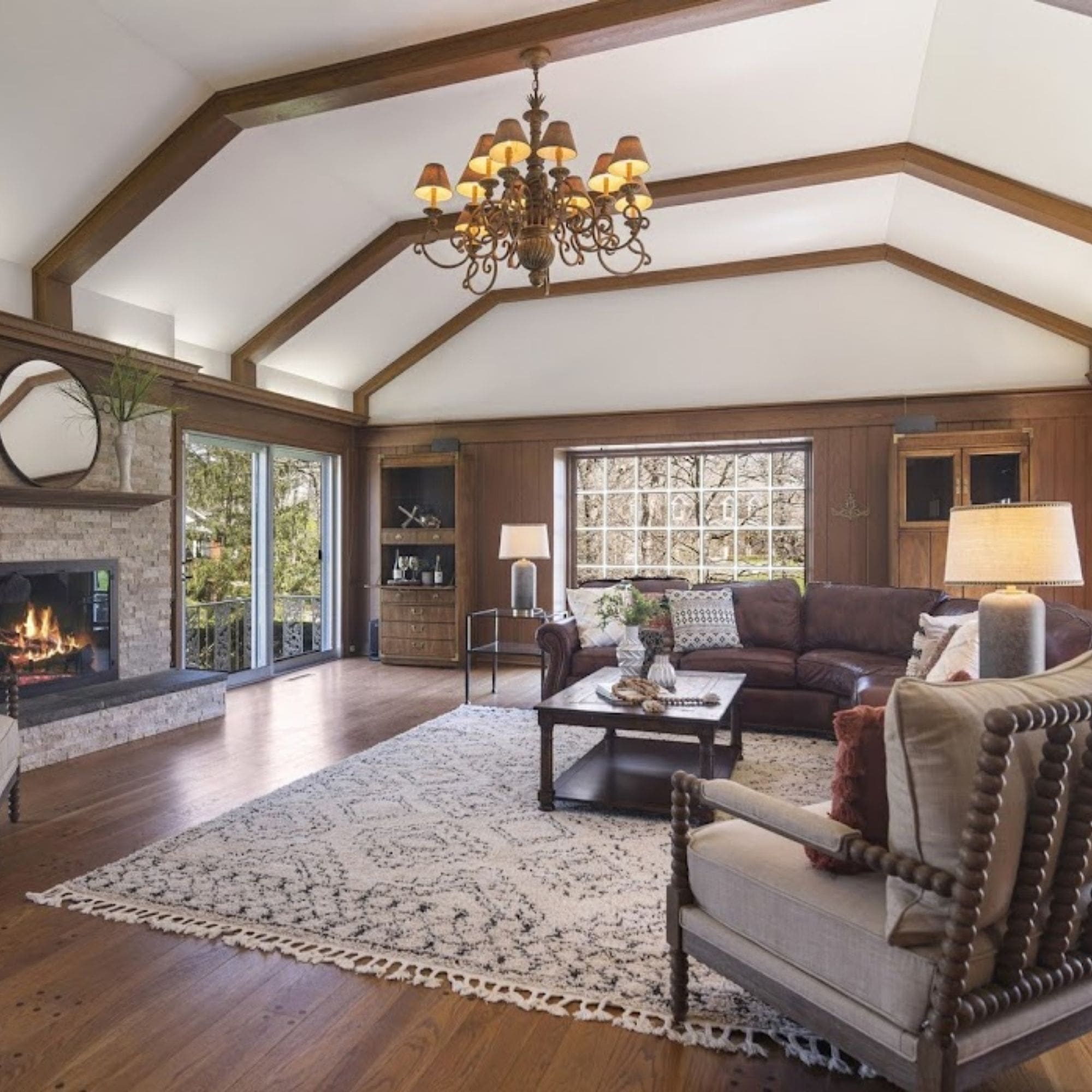  Warm and inviting home staged living room with a fireplace and wood paneling.