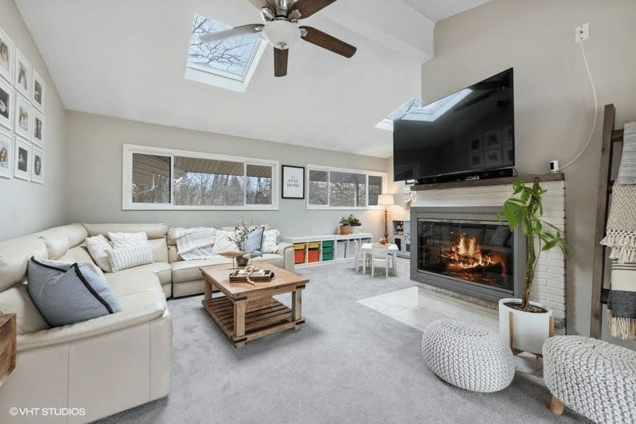 A cozy staged living room featuring a fireplace, comfortable couches, and a television.