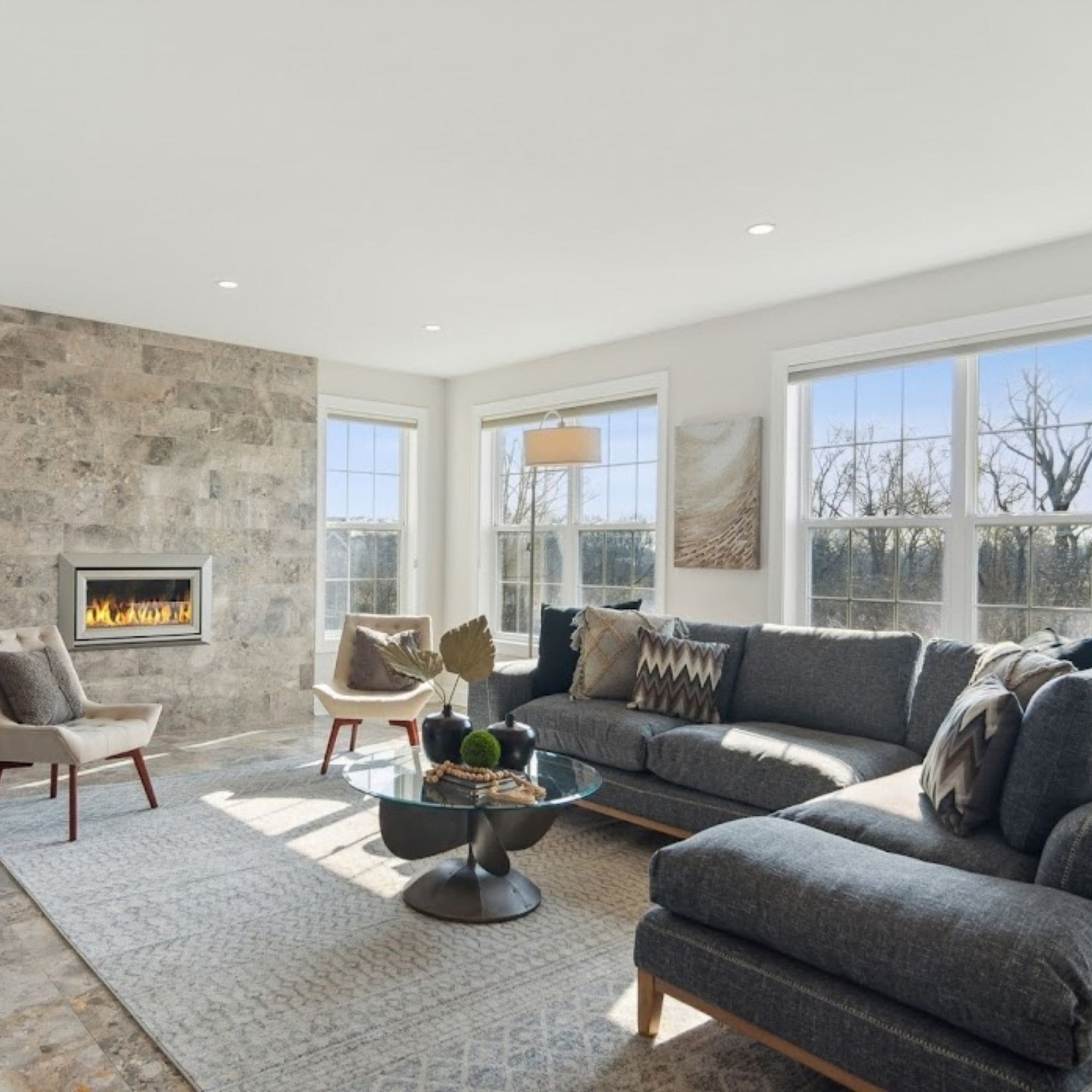 Relaxing home staged living space featuring a stunning stone fireplace and a plush couch.