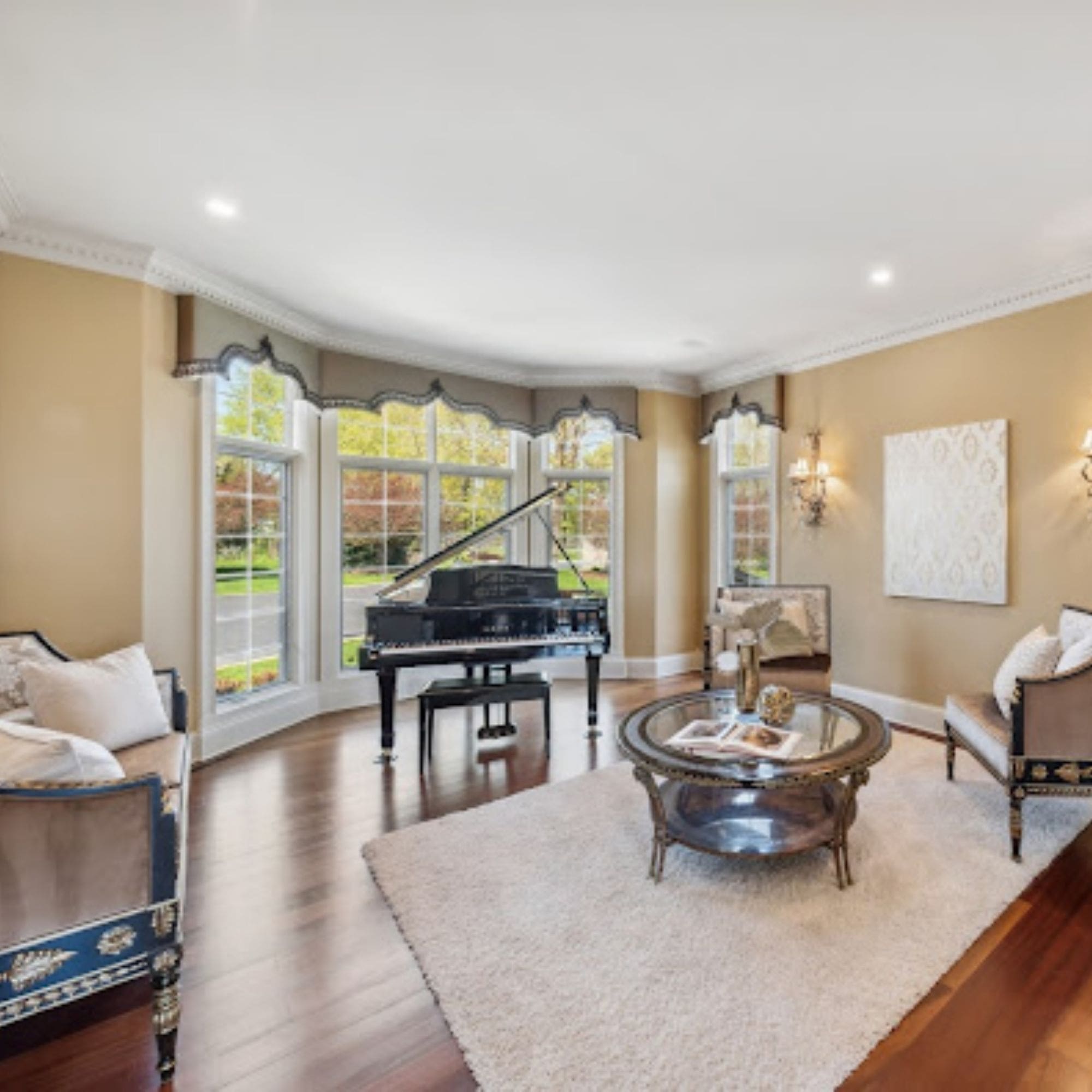 A cozy staged living room with a grand piano and comfortable chairs, perfect for relaxing or entertaining guests.