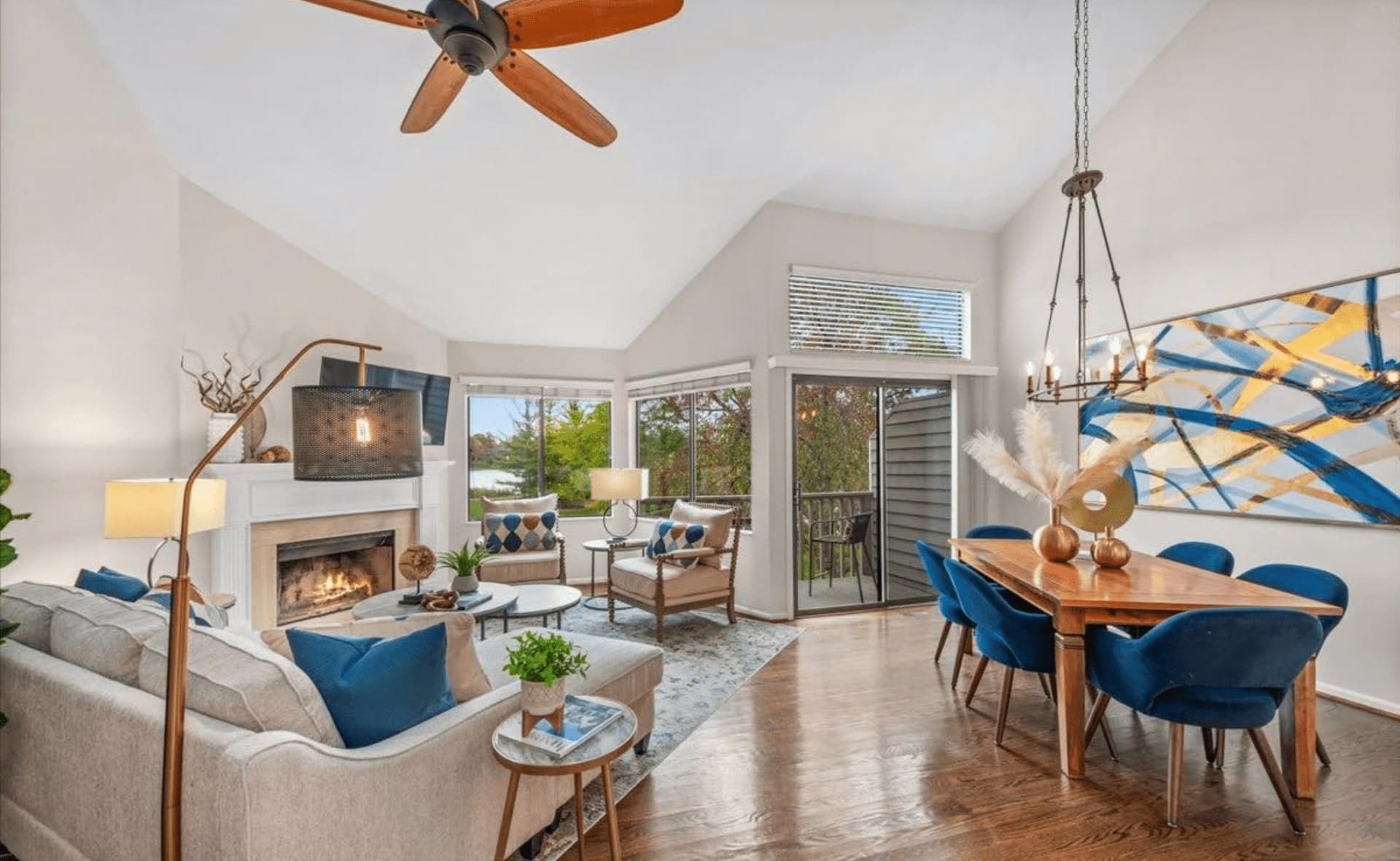 A spacious staged living room featuring beautiful hardwood floors and a stylish ceiling fan.