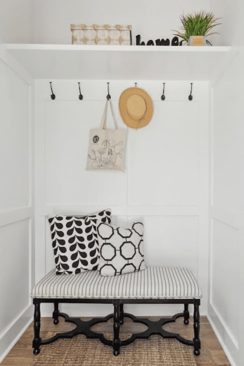 A white bench adorned with a hat rack and cushions, providing a comfortable seating option.