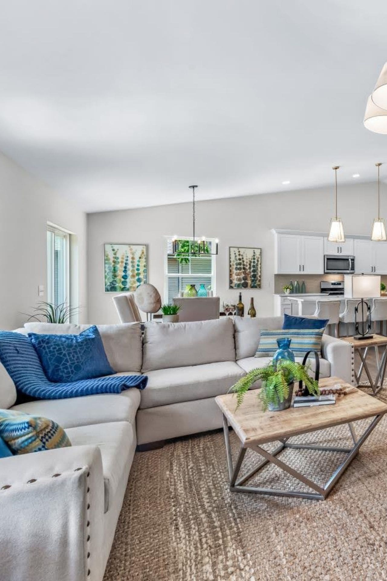 A well-organized staged living space with a cozy couch, a stylish coffee table, and a fully-equipped kitchen.