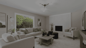 Modern living room with neutral cream sofas, a white painted brick fireplace, a square wood coffee table, two dark green ottomans, and a large picture window.